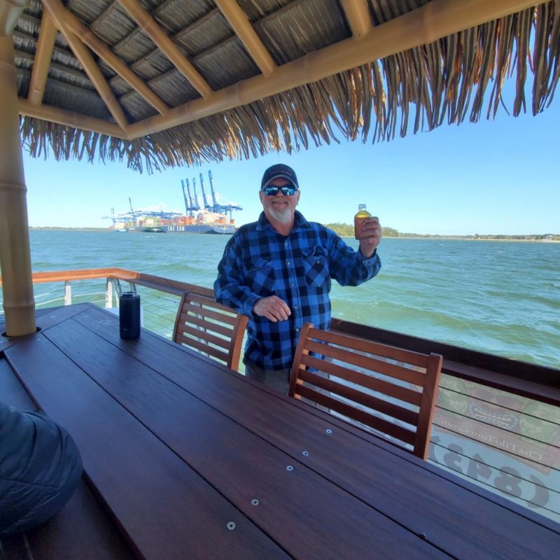 Man holding a drink on a boat in Charleston